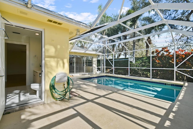 view of swimming pool featuring a lanai and a patio area