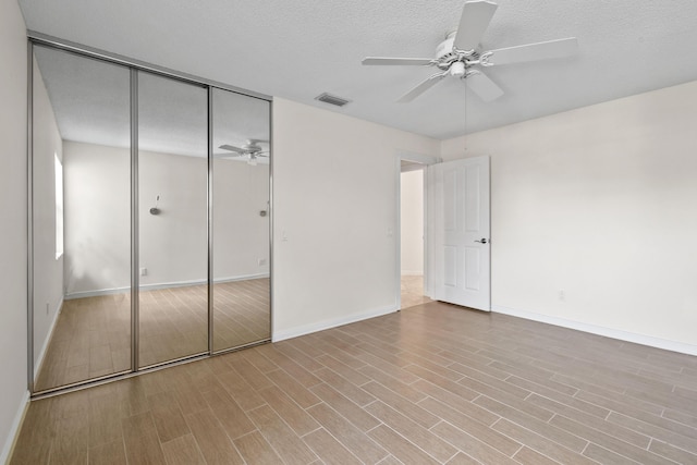 unfurnished bedroom with ceiling fan, a closet, and a textured ceiling