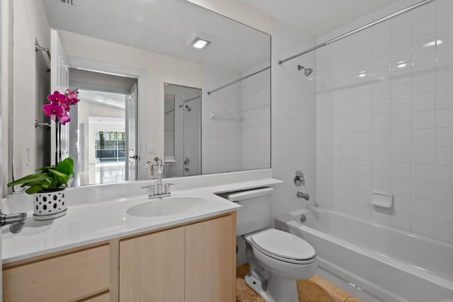 full bathroom featuring toilet, tiled shower / bath combo, and vanity