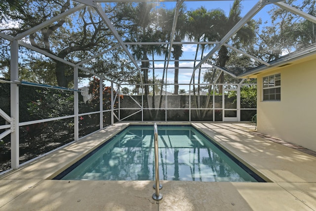 view of pool featuring glass enclosure and a patio area