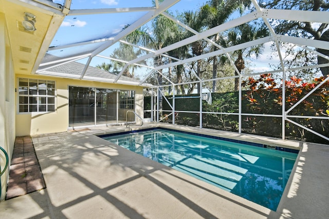 view of pool featuring glass enclosure and a patio