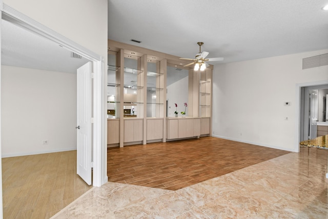 unfurnished living room featuring ceiling fan