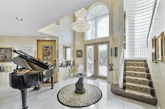 entrance foyer featuring a high ceiling, a chandelier, and french doors