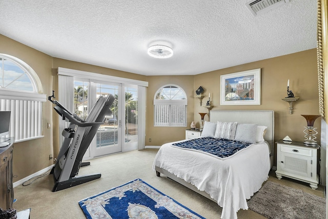 bedroom with carpet floors, access to exterior, and a textured ceiling