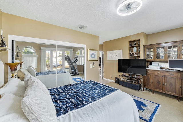 bedroom featuring access to outside, a textured ceiling, and light carpet