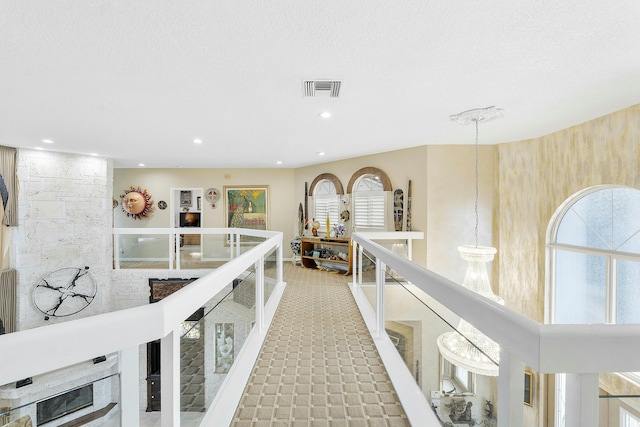 hallway featuring a wealth of natural light and a textured ceiling