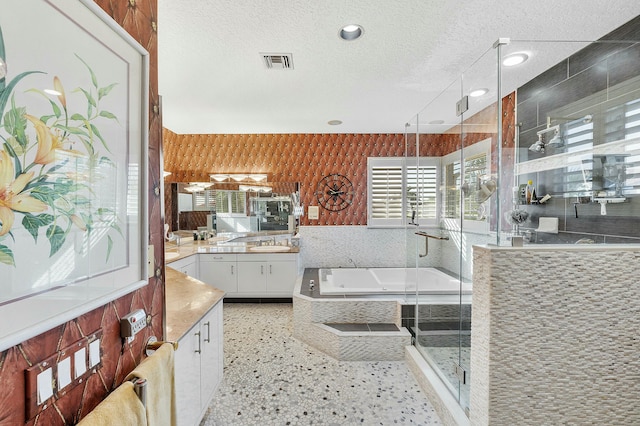 bathroom featuring a textured ceiling, shower with separate bathtub, and vanity