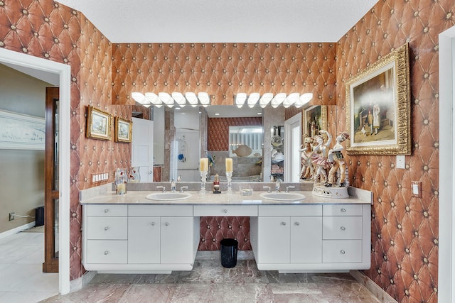 bathroom featuring a textured ceiling and vanity