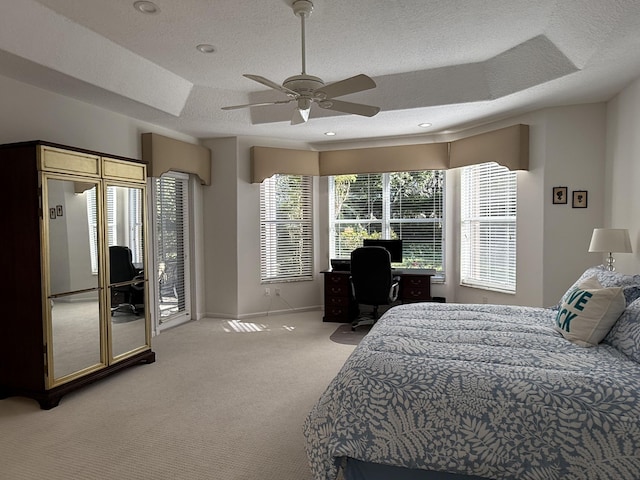 bedroom with a textured ceiling, light carpet, a raised ceiling, access to outside, and ceiling fan