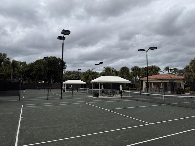 view of tennis court with a gazebo and basketball hoop