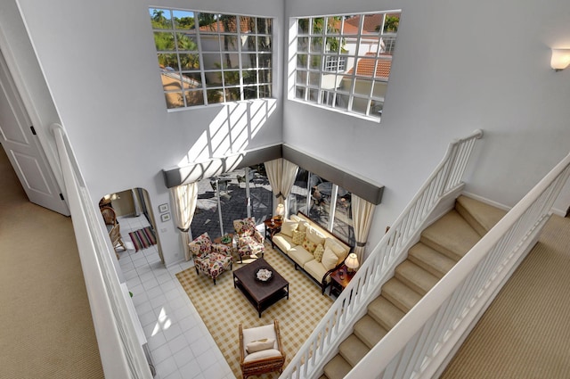 staircase with tile patterned flooring and a high ceiling