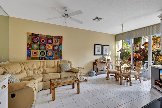 tiled living room featuring ceiling fan and a textured ceiling