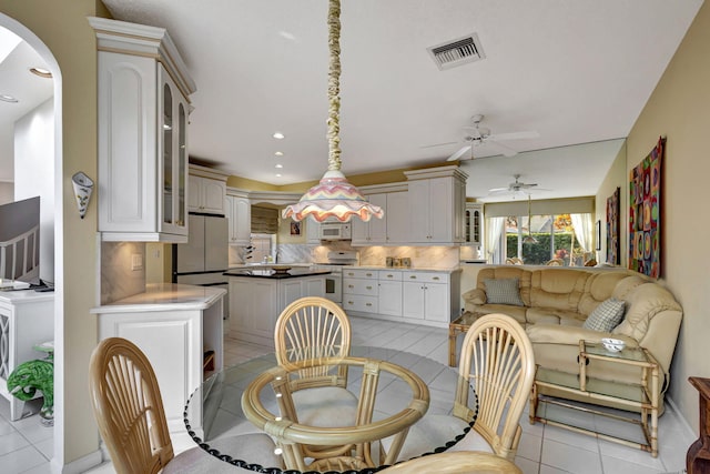 dining space with ceiling fan, sink, and light tile patterned floors