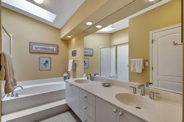 bathroom with shower with separate bathtub, a textured ceiling, vanity, vaulted ceiling with skylight, and tile patterned flooring