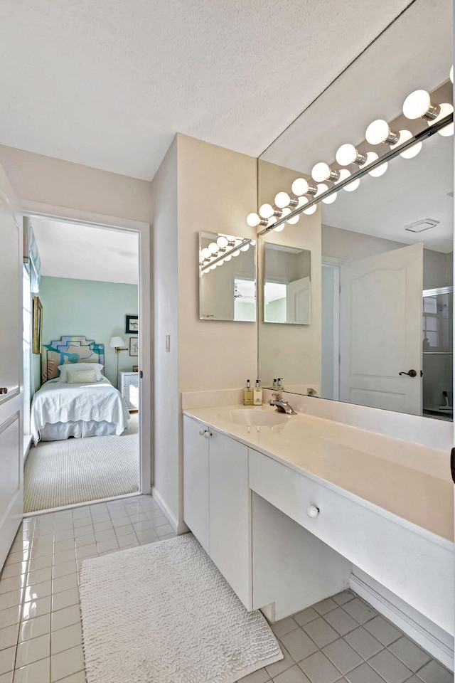 bathroom featuring vanity, tile patterned flooring, and a textured ceiling