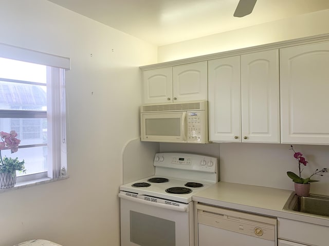 kitchen featuring white cabinetry, sink, white appliances, and a healthy amount of sunlight