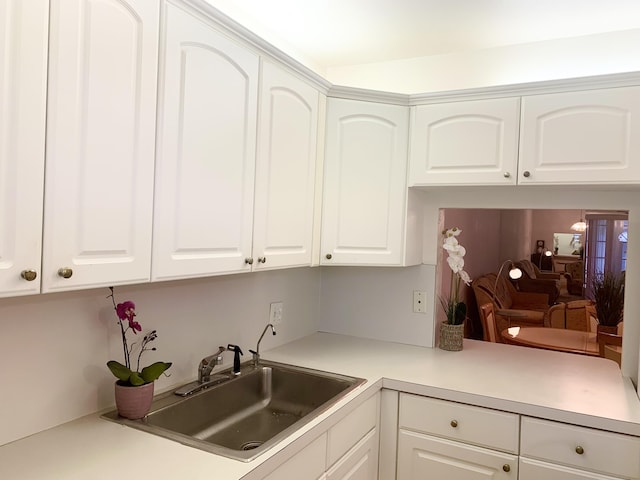 kitchen featuring white cabinetry and sink