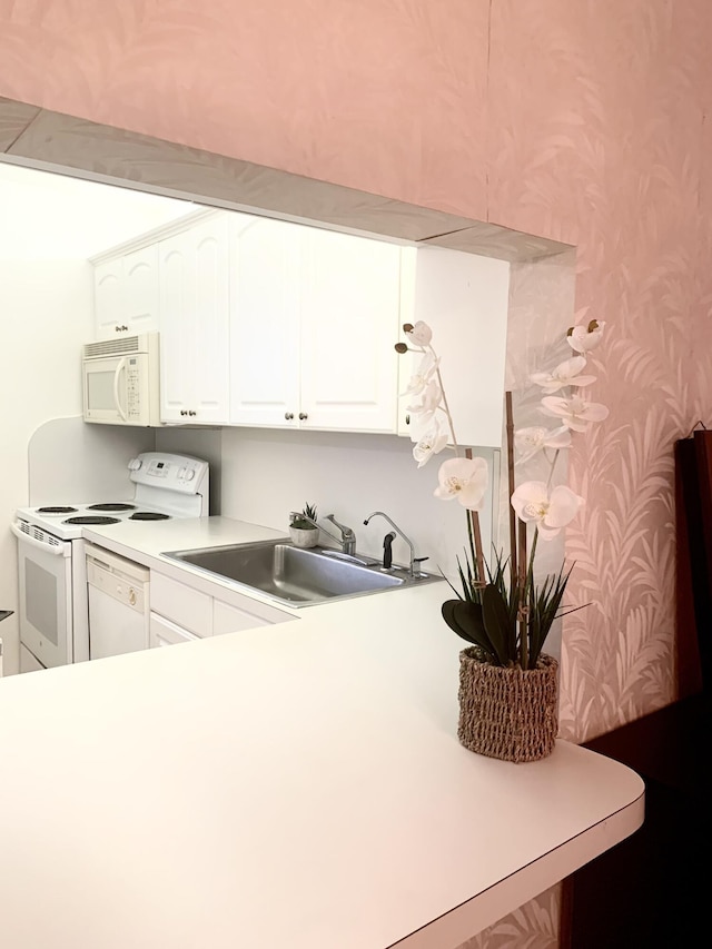 kitchen with sink, white appliances, and white cabinets