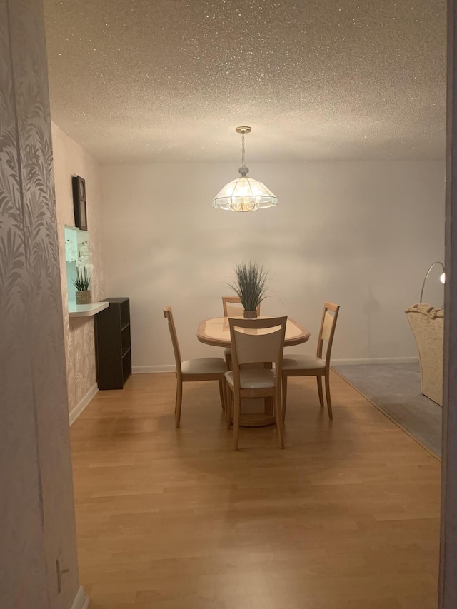 dining area with a textured ceiling and hardwood / wood-style floors