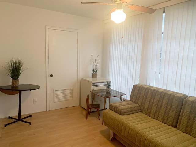 living area with ceiling fan and light hardwood / wood-style floors