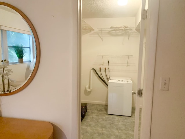 laundry room featuring a textured ceiling and washer / clothes dryer