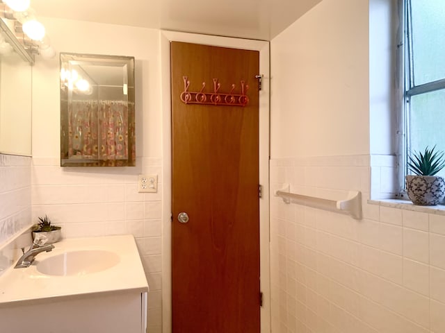 bathroom featuring tile walls and vanity