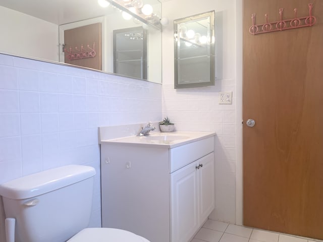 bathroom featuring tile walls, toilet, vanity, and tile patterned flooring