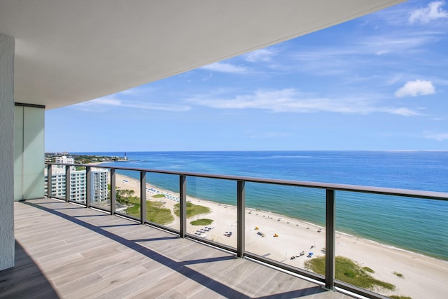 balcony featuring a water view and a beach view