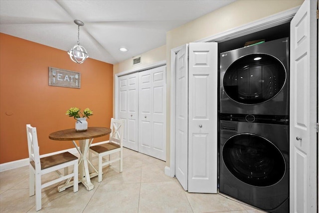 washroom featuring light tile patterned floors and stacked washer and clothes dryer