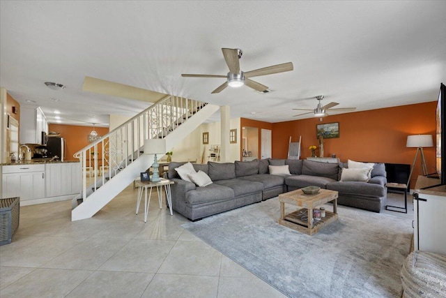 living room featuring ceiling fan, light tile patterned floors, and sink