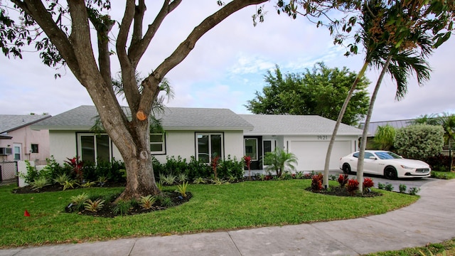 single story home with a garage and a front lawn