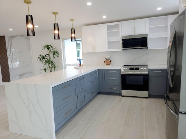 kitchen featuring backsplash, white cabinetry, stainless steel appliances, and hanging light fixtures