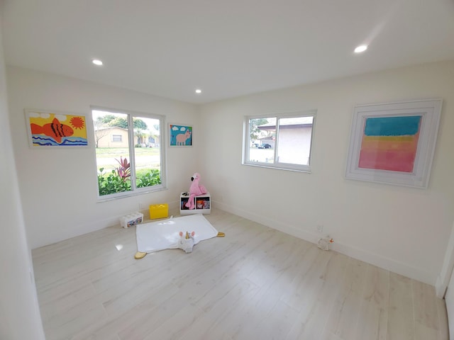 recreation room with a wealth of natural light and light hardwood / wood-style floors