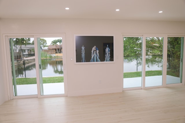 entryway featuring a water view and light wood-type flooring