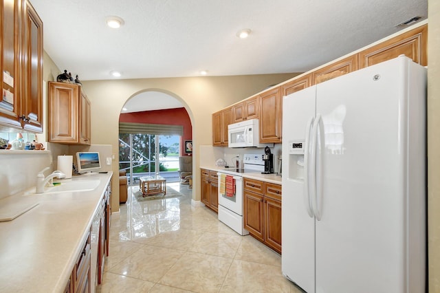 kitchen with sink, white appliances, and light tile patterned floors