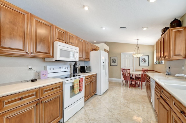 kitchen with white appliances, light tile patterned floors, sink, decorative light fixtures, and lofted ceiling