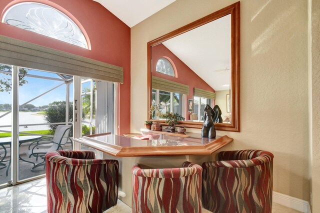 dining space featuring vaulted ceiling and a water view