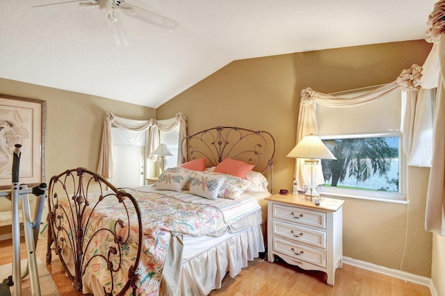 bedroom featuring light hardwood / wood-style floors, vaulted ceiling, and ceiling fan