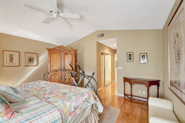 bedroom featuring ceiling fan, a closet, lofted ceiling, and light hardwood / wood-style flooring