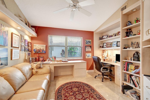 home office featuring ceiling fan, built in shelves, built in desk, and vaulted ceiling