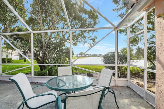 sunroom featuring a water view