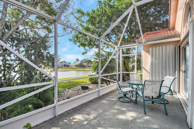 unfurnished sunroom featuring a water view