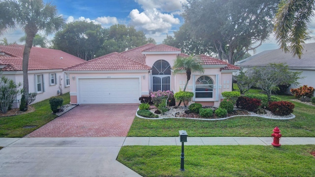 mediterranean / spanish-style house with a garage and a front lawn