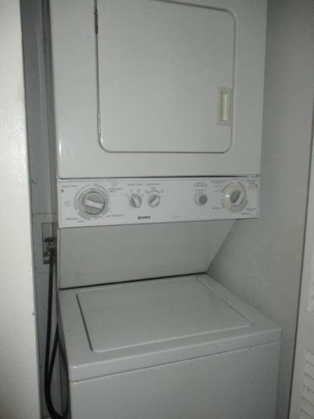 clothes washing area featuring stacked washer / dryer