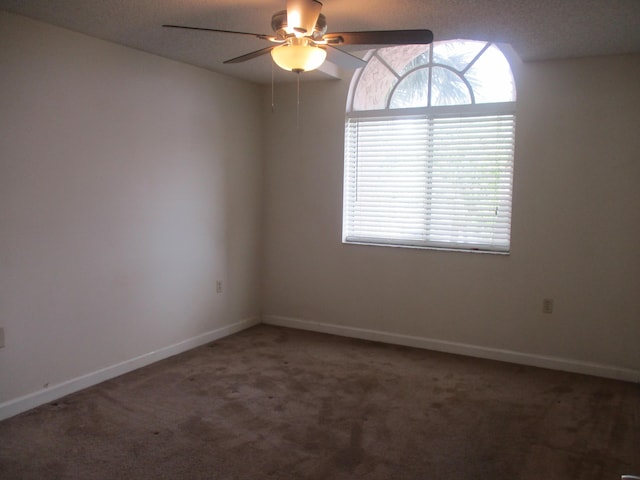 empty room with carpet floors, baseboards, and a ceiling fan