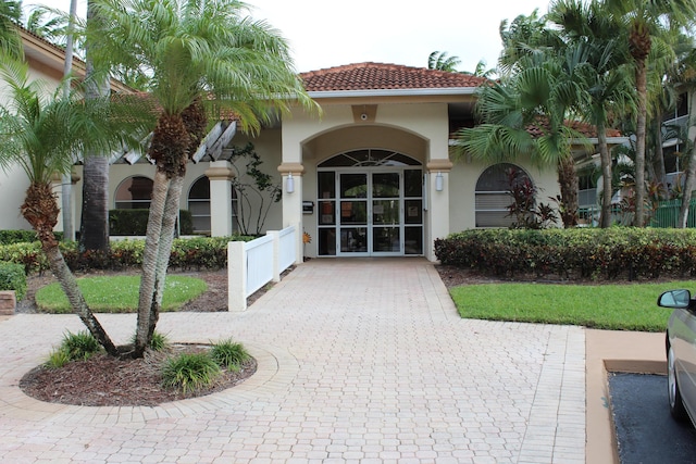 view of exterior entry featuring a tile roof and stucco siding