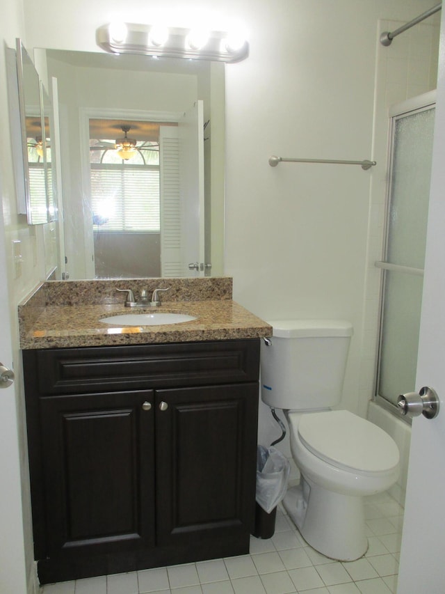 bathroom with toilet, an enclosed shower, vanity, and a ceiling fan