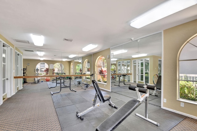 workout area with visible vents, plenty of natural light, and baseboards