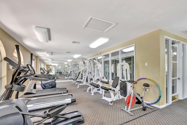 workout area featuring attic access, visible vents, and baseboards