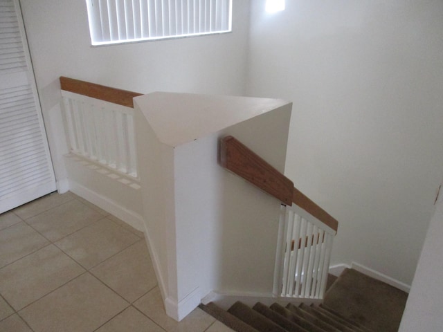 stairway with visible vents, baseboards, and tile patterned floors